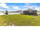Expansive backyard featuring lush green grass and a screened-in patio at 944 Old Windsor Way, Spring Hill, FL 34609