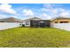 Well-maintained backyard with lush green grass and a screened-in patio, perfect for outdoor enjoyment at 944 Old Windsor Way, Spring Hill, FL 34609
