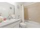Clean bathroom featuring a vanity, toilet, and shower/tub combo with neutral tile and a decorative mirror at 944 Old Windsor Way, Spring Hill, FL 34609