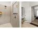 Shower room with tiled walls, and glass; toiletries are partially visible; and an open doorway to the main bedroom at 944 Old Windsor Way, Spring Hill, FL 34609
