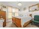 Bright bedroom features a wooden bed frame, neutral curtains, a chandelier, and a decorative sunburst mirror at 944 Old Windsor Way, Spring Hill, FL 34609