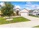 Single-story house featuring a well-maintained lawn, a driveway leading to a two-car garage, and tasteful landscaping at 944 Old Windsor Way, Spring Hill, FL 34609