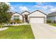 Beautiful single-story home with a manicured lawn, white rock garden, and neutral color palette at 944 Old Windsor Way, Spring Hill, FL 34609