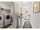 Bright hallway featuring a glass-top console table, a zebra-striped rug, and access to the laundry room at 944 Old Windsor Way, Spring Hill, FL 34609