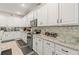 Contemporary kitchen featuring white cabinets, granite countertops, stainless steel appliances, and tile backsplash at 944 Old Windsor Way, Spring Hill, FL 34609