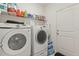 Well-equipped laundry room with modern washer and dryer units, wire shelving, and easy access to the exterior at 944 Old Windsor Way, Spring Hill, FL 34609