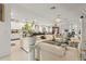 Bright, open living space with white tile floors, a sleek white sofa, and an open concept connecting kitchen, dining, and living areas at 944 Old Windsor Way, Spring Hill, FL 34609