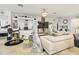 Spacious living room with unique decor elements, a white sofa, black accent chair, large screen TV, and stylish shelving at 944 Old Windsor Way, Spring Hill, FL 34609