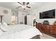 Bright main bedroom with a ceiling fan, TV, and furniture; the en-suite bathroom is partially visible at 944 Old Windsor Way, Spring Hill, FL 34609