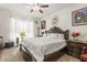 Bedroom featuring a ceiling fan, window with sheer curtains, decorative wall decor, and furniture at 944 Old Windsor Way, Spring Hill, FL 34609