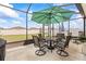 Spacious screened-in patio with umbrella, seating, and views of the well-maintained backyard at 944 Old Windsor Way, Spring Hill, FL 34609
