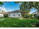 The backyard has a freshly cut lawn, with a screened-in patio and privacy hedges at 9608 Greenpointe Dr, Tampa, FL 33626