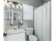 Bright bathroom with white vanity, decorative lighting, and a neutral shower curtain at 9608 Greenpointe Dr, Tampa, FL 33626