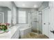 Well-lit bathroom with a soaking tub, tiled walk-in shower, and a double vanity with white countertops at 9608 Greenpointe Dr, Tampa, FL 33626