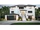 A modern two-story home with black accents and lush landscaping at 10126 Tarpon Dr, Treasure Island, FL 33706