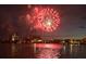 Brilliant red fireworks explode over the water, with reflections adding to the spectacular view at 10126 Tarpon Dr, Treasure Island, FL 33706