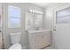 Updated bathroom includes a toilet, white vanity with marble-look countertop, and decorative light fixture at 10446 Baylor Dr, Spring Hill, FL 34608