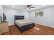 Comfortable bedroom features wood floors, a ceiling fan, window, door and a queen size bed at 10446 Baylor Dr, Spring Hill, FL 34608