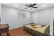 This well-lit bedroom boasts wood floors, ceiling fan, a window, and closet at 10446 Baylor Dr, Spring Hill, FL 34608