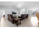 Spacious living room featuring tile floors, comfortable leather seating, and a modern chandelier at 10446 Baylor Dr, Spring Hill, FL 34608