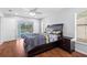 Spacious main bedroom featuring wood floors and sliding glass door access to the pool at 10446 Baylor Dr, Spring Hill, FL 34608
