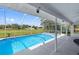 Sparkling pool with screen enclosure, patio, and scenic views for outdoor enjoyment at 10446 Baylor Dr, Spring Hill, FL 34608