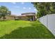 Well-maintained backyard featuring a lush lawn, covered patio, and white vinyl fence at 10512 Scenic Hollow Dr, Riverview, FL 33578