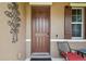 A charming brown front door featuring sidelight, decorative scrollwork and chair seating at 10512 Scenic Hollow Dr, Riverview, FL 33578