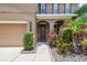 Close-up view of a front entrance with an arched portico, plants and shrubs at 10512 Scenic Hollow Dr, Riverview, FL 33578