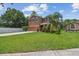 Two-story home featuring well-manicured lawn, mature trees, and a side-entry two-car garage at 10512 Scenic Hollow Dr, Riverview, FL 33578