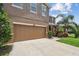 Home featuring a two-car attached garage with a concrete driveway and manicured landscaping at 10512 Scenic Hollow Dr, Riverview, FL 33578