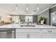 Kitchen island with stainless steel dishwasher and sink, pendant lighting, and open floor plan at 10512 Scenic Hollow Dr, Riverview, FL 33578