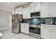 A modern kitchen equipped with stainless steel appliances, a tile backsplash, and white cabinets at 10512 Scenic Hollow Dr, Riverview, FL 33578