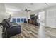 Spacious living room featuring hardwood floors, ceiling fan, and comfortable black leather reclining sofa at 10512 Scenic Hollow Dr, Riverview, FL 33578