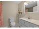 Bathroom featuring a toilet and a vanity sink with mirror and tile flooring at 12412 Lakeview Dr, Dade City, FL 33525