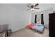 Bright bedroom with wood-look floors, a ceiling fan and natural light from the window at 12412 Lakeview Dr, Dade City, FL 33525
