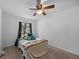Cozy bedroom with a ceiling fan and a window with dark curtains at 12412 Lakeview Dr, Dade City, FL 33525