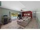 Bright living room with sliding glass doors to the pool, sectional sofa, and arcade game at 12412 Lakeview Dr, Dade City, FL 33525