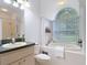 Elegant bathroom features a soaking tub with a large window and a vanity sink at 1332 Osceola Hollow Rd, Odessa, FL 33556