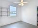 Neutral bedroom with a window offering natural light and wall mounted shelving for storage at 1332 Osceola Hollow Rd, Odessa, FL 33556