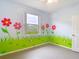 Bright bedroom featuring colorful mural, ceiling fan, and view of the yard at 1332 Osceola Hollow Rd, Odessa, FL 33556