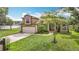 Inviting home exterior featuring lush green lawn, mature trees, and an attached garage at 1332 Osceola Hollow Rd, Odessa, FL 33556