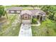 Front exterior featuring an attached garage, arched windows, and mature landscaping at 1332 Osceola Hollow Rd, Odessa, FL 33556