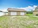 Detached two car garage with roll up doors and lush green yard at 1332 Osceola Hollow Rd, Odessa, FL 33556