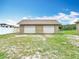 View of a two car detached garage with dual metal doors and beige paint at 1332 Osceola Hollow Rd, Odessa, FL 33556