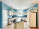 Bright kitchen features white cabinetry, an island with bar seating, and wood-look flooring at 1332 Osceola Hollow Rd, Odessa, FL 33556