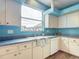 The kitchen is bright and open, with white appliances and blue walls at 1332 Osceola Hollow Rd, Odessa, FL 33556
