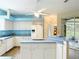 View of the kitchen, bright white appliances, and an island with bar seating at 1332 Osceola Hollow Rd, Odessa, FL 33556