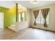 Cozy living room with wood-look floors, large window with curtains, and entry with chandelier at 1332 Osceola Hollow Rd, Odessa, FL 33556