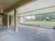 Screened patio with concrete floor overlooks large yard and property's outdoor landscape at 1332 Osceola Hollow Rd, Odessa, FL 33556